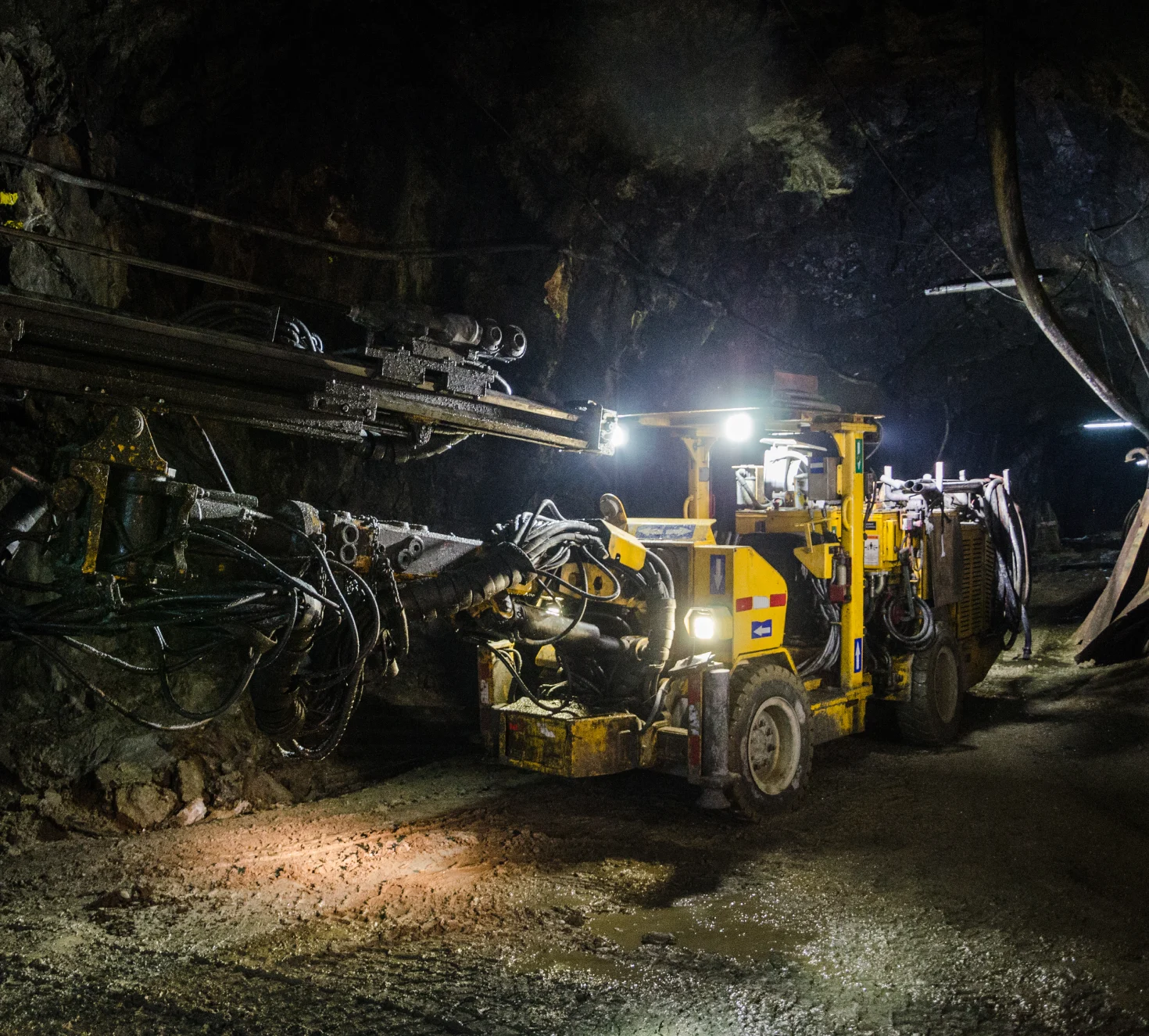 Large yellow underground mining machine in a rock tunnel, illustrating modern mining operations.